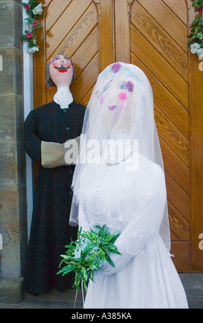 In carta pesta figure religiose; la sposa e lo sposo in attesa presso la chiesa Hinderwell festival. Foto Stock