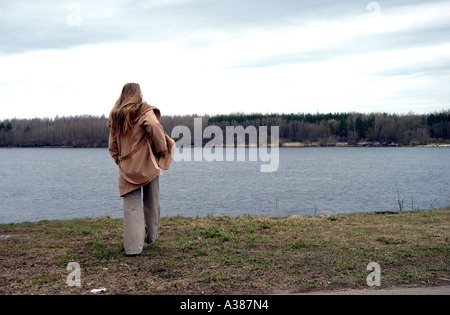 Giovane donna guarda al fiume di Narva la nuova Unione europea delle frontiere esterne su un lato è Estonia e sull'altro lato è la Russia Foto Stock