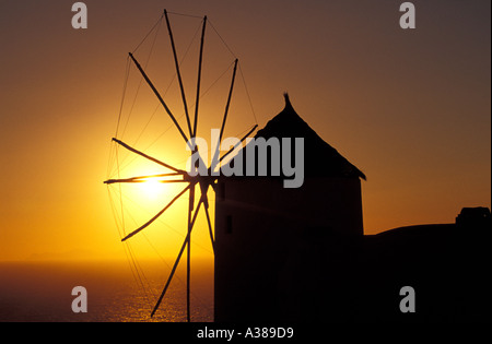 Mulino a vento sulla isola di Santorini al tramonto, Grecia Foto Stock