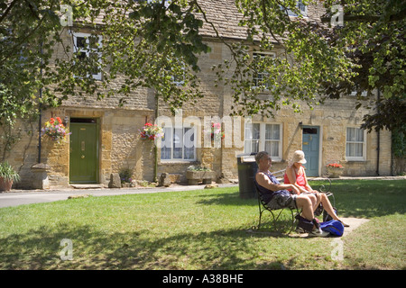 Visitatori rilassante in un angolo della piazza del mercato nel Cotswold città di sedili Stow-su-il-Wold, Gloucestershire Foto Stock