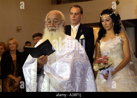 Il sacerdote di Lettura dalla Bibbia durante un greco ortodosso di cerimonia nuziale. Foto Stock