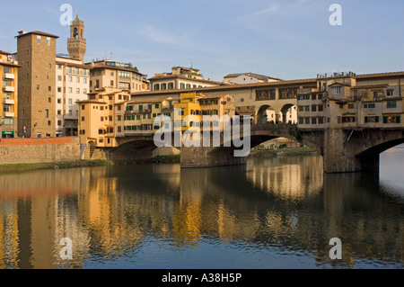 Un Occidente vista laterale del Ponte Vecchio e edifici tradizionali si riflette nel fiume Arno. Foto Stock