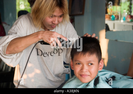 Barbiere il taglio di un giovane ragazzo s capelli in Thanh da area di Saigon Foto Stock