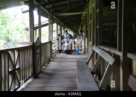Famiglia radunata sul balcone della loro longhouse sulle rive del Sungai Terika, Sarawak, Borneo, Malaysia Foto Stock