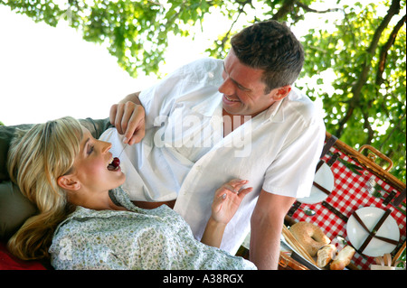 Verliebtes Paar bei einem Picknick am See, amorosa giovane avente un picnic in riva al lago Foto Stock