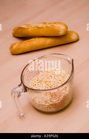 Urid dal bianco in un misurino e due baguette Foto Stock