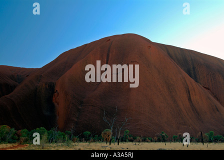 Ayers Rock poco dopo l'alba come visto lungo la base a piedi intorno a Uluru Foto Stock