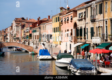 Italia Veneto Venezia Fondamenta degli Ormesini nel sestiere di Cannaregio con barche ormeggiate lungo il canale e la gente camminare lungo Foto Stock