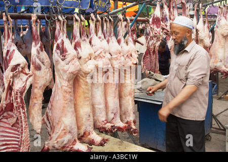 Uighur macellaio al mercato di carne Foto Stock