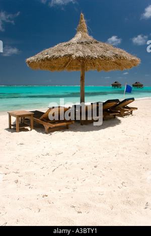 WEST INDIES Caraibi St Vincent e Grenadine Canouan Palapa Rifugio con tetto in paglia e lettini sulla spiaggia Godahl al Raffles Resort. Foto Stock