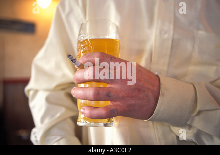 Uomo a fumare e bere in un pub Inghilterra REGNO UNITO Foto Stock