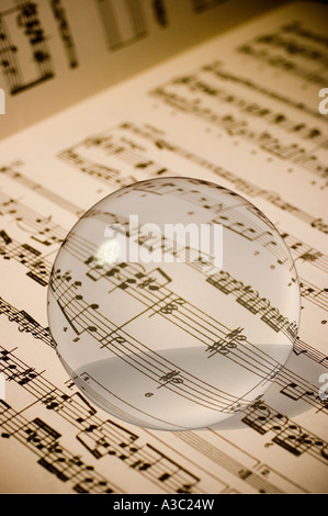 Una sfera di vetro sulla pagina di uno spartito musicale Foto Stock