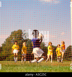 Vista da dietro come un soccer goalie catture una sfera impedendo la squadra avversaria dal punteggio Foto Stock