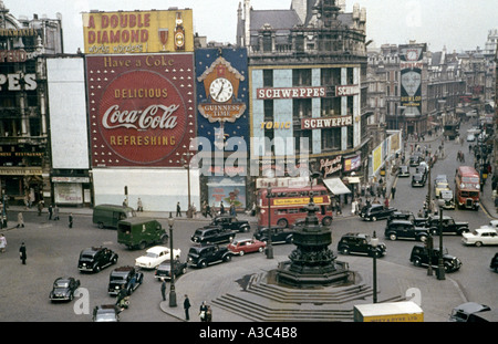 Piccadilly Circus, Londra, mostra cartelloni pubblicitari coca cola, Double Diamond e Schweppes con vecchi veicoli e autobus alla fine degli anni '1950, primi anni '1960 Foto Stock