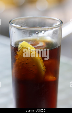 Chiusura del bicchiere di cola con una fettina di limone su un outdoor cafe tabella Foto Stock