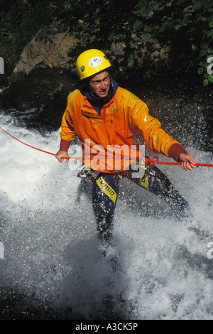 Canyoning, un uomo la scalata verso il basso attraverso una cascata, Austria Foto Stock