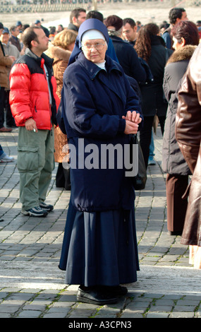 Una suora attende per la messa domenicale in Piazza San Pietro per iniziare a Città del Vaticano Roma Italia Foto Stock