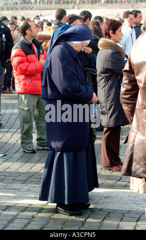 Una suora attende per la messa domenicale in Piazza San Pietro per iniziare a Città del Vaticano Roma Italia Foto Stock