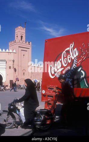 Una donna musulmana in tradizionali abiti musulmani vicino ad una Coca Cola autocarro Piazza Djemaa el Fna a Marrakech marocco Foto Stock