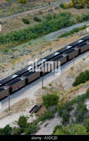 Carico e vuoto del carbone vetture stanno fianco a fianco in questo arial vista fiume vicino ai binari della ferrovia è visibile Foto Stock