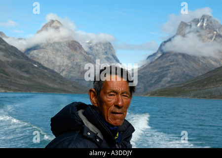 Ritratto Greenlander Inuit nel fiordo Qinngertivaq con alte montagne Solporten Eastgreenland Foto Stock