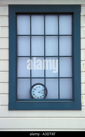 Un orologio seduto sul davanzale del vecchio edificio in legno con tenda bianca dietro di esso, visto attraverso la finestra, San Francisco, CA Foto Stock