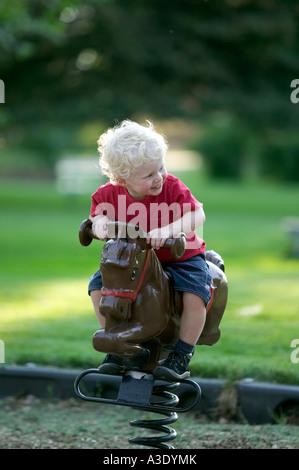 Il Toddler ragazzo giocattolo passeggiate sul pony città parco giochi, Salida, Colorado, STATI UNITI D'AMERICA Foto Stock