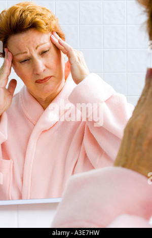 La donna vive un mal di testa, eventualmente un mal di testa di emicrania. Foto Stock