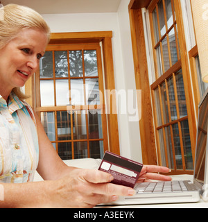 Close-up di una donna matura lo shopping online Foto Stock