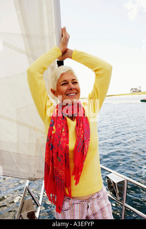 Close-up di una donna matura in piedi in una barca a vela e sorridente Foto Stock