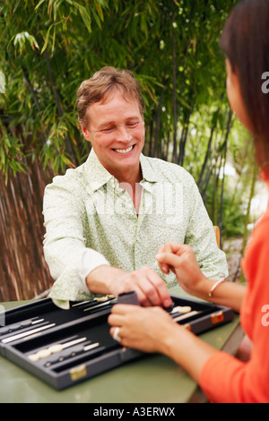 Close-up di un uomo maturo di giocare a backgammon con una donna matura Foto Stock