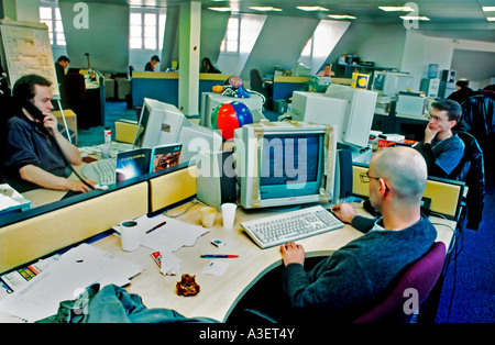 Giovani uomini adulti lavora nel portale Internet in Open Space Office, Parigi Francia, "Yahoo.com' guardando lo schermo del computer Foto Stock