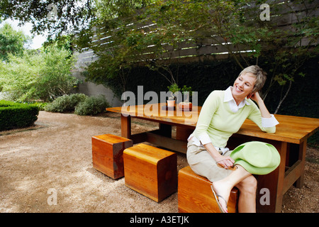 Coppia donna seduta su uno sgabello e sorridente Foto Stock