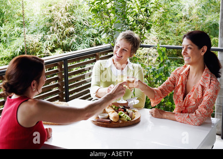 Tre donne mature bevendo champagne flauti Foto Stock