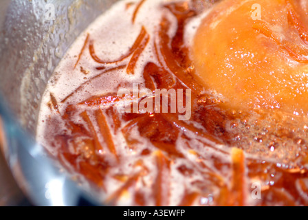 Rendendo la marmellata di arance a buccia di arancia in ebollizione a preservare la coppa con una mussola che contiene i punti di interfacciamento di chiazza e midollo REGNO UNITO Foto Stock