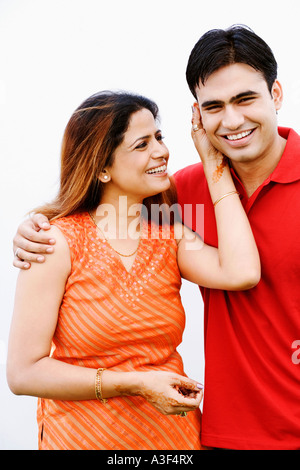 Ritratto di una giovane donna tirando l'orecchio di una metà uomo adulto e sorridente Foto Stock