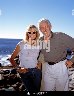 Coppia in pensione che pongono in riva al mare Foto Stock