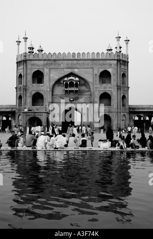 Vista posteriore di un gruppo di persone sedute al di fuori di una moschea Jama Masjid, New Delhi, India Foto Stock