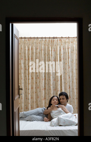 Coppia giovane disteso sul letto Foto Stock