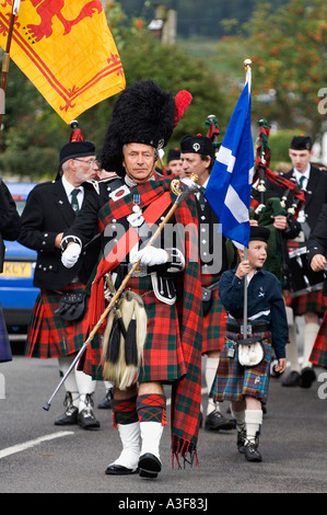 Alloa Bowmar Pipe Band Marching anche se sulla strada principale del villaggio scozzese Killin Scozia Scotland Foto Stock