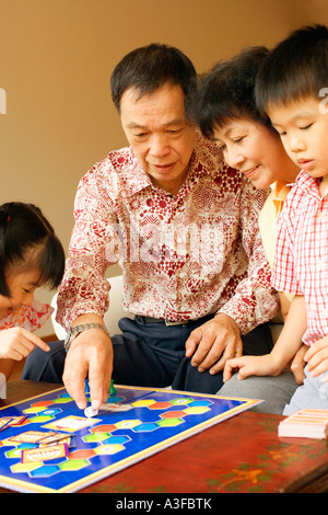 Close-up di una ragazza e un ragazzo giocando a un gioco con i loro nonni Foto Stock