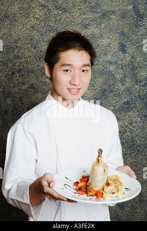 Ritratto di un giovane uomo con un piatto di cibo Foto Stock