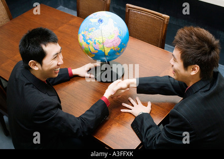 Angolo di alta vista di due imprenditori stringono le mani Foto Stock