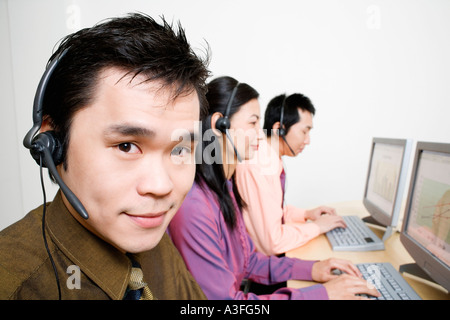 Tre rappresentanti del servizio clienti lavorando sul computer Foto Stock