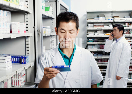 Il farmacista maschio tenendo la medicina in una camera di deposito Foto Stock