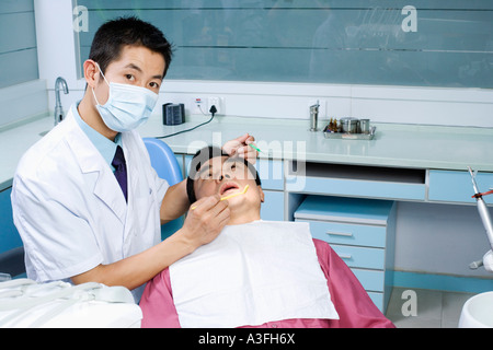 Close-up di un maschio di dentista l' esame di un paziente di sesso maschile Foto Stock