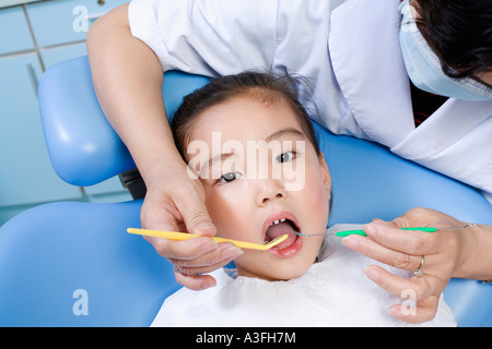 Close-up di una femmina di dentista esaminando una ragazza i denti Foto Stock