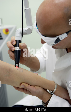 Specialista della pelle MD von Schmiedeberg durante l'eliminazione di un tatuaggio per mezzo della tecnologia laser Foto Stock