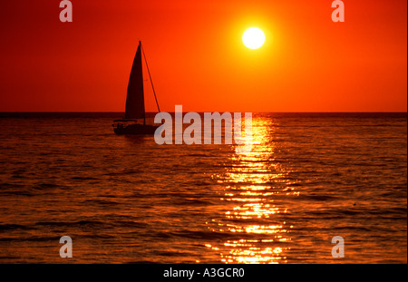 Barca a vela al tramonto Foto Stock