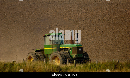 Il trattore si muove attraverso il campo arato Foto Stock